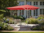 Ein exzentrischer BlueSun Sonnenschirm steht in einem privaten Garten und beschattet eine Terrasse.