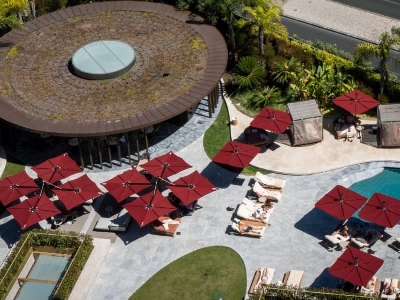 Umbrosa Sonnenschirme an einem Wasserbecken in einer Tropischen Umgebung.