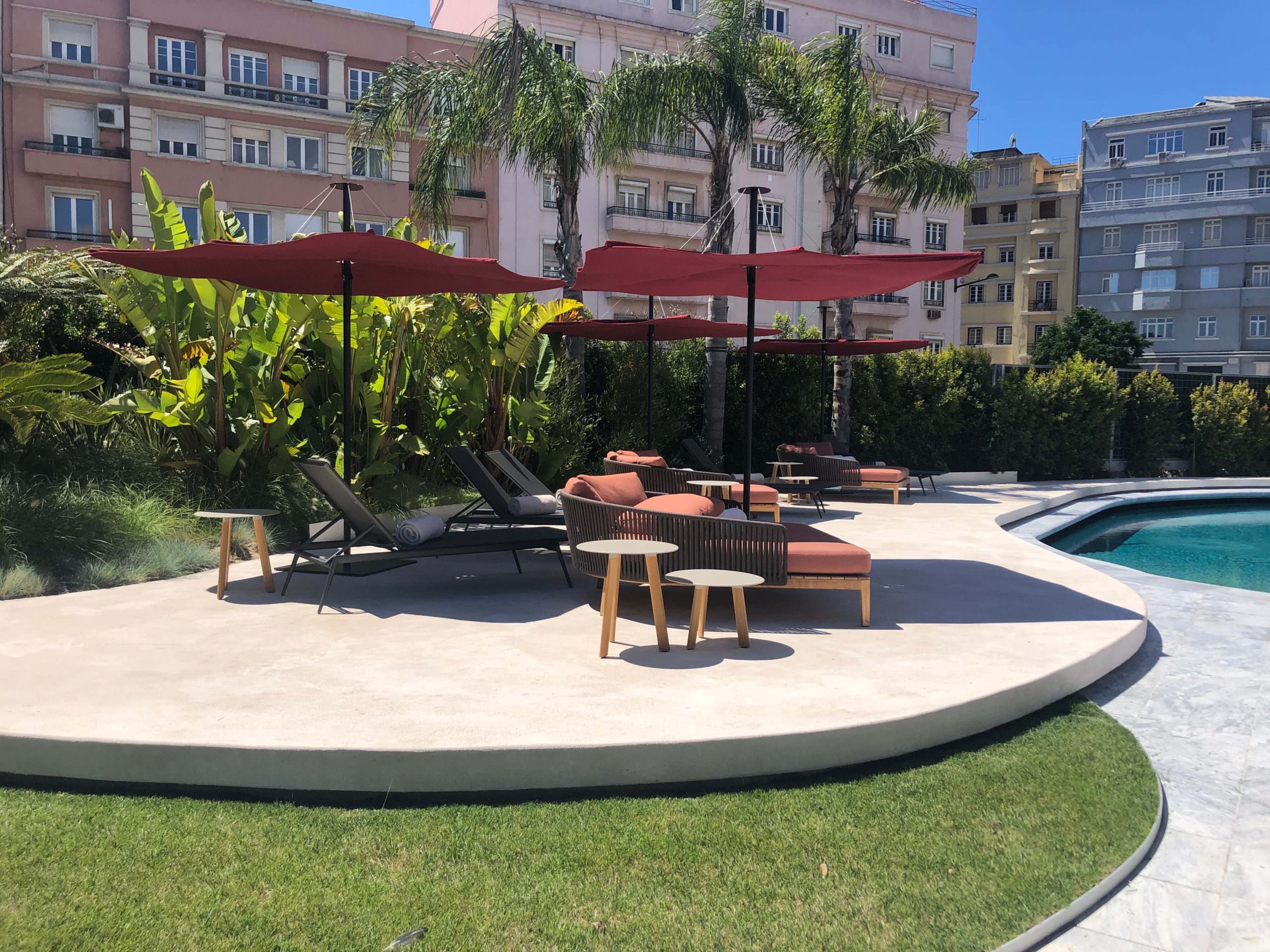 Umbrosa Pool Umbrosa Sonnenschirme überdachen mehrere Liegestühle.