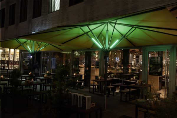 Grün leuchtende LUME-1 Sonnenschirmbeleuchtungen.